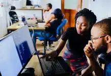 woman and man sitting in front of monitor