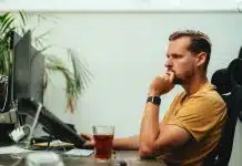 un homme assis à son bureau devant ses écrans d'ordinateur